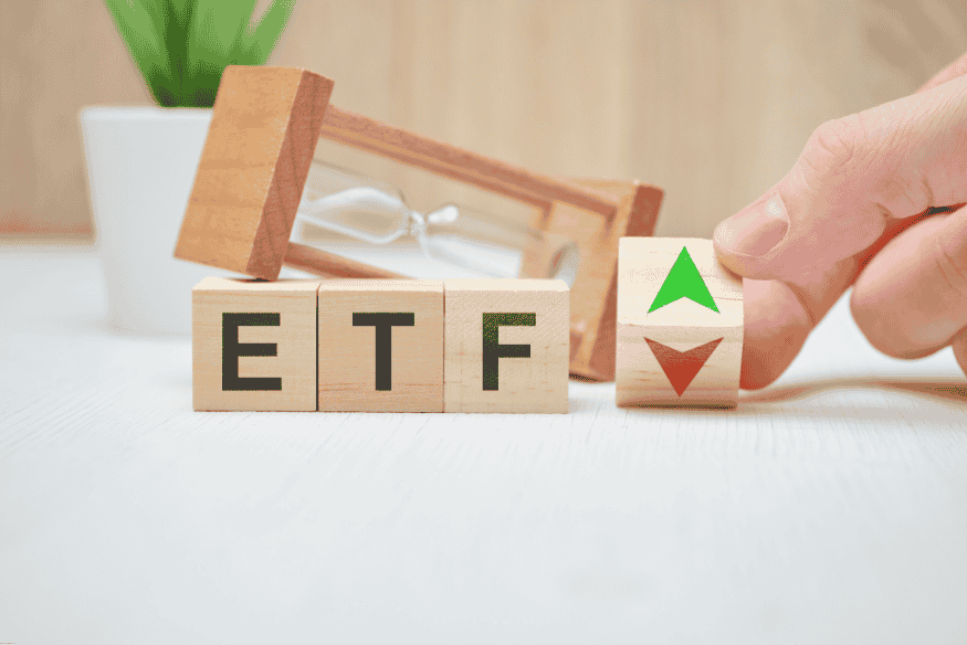 Wooden blocks showing ETF with market trend arrows up and down
