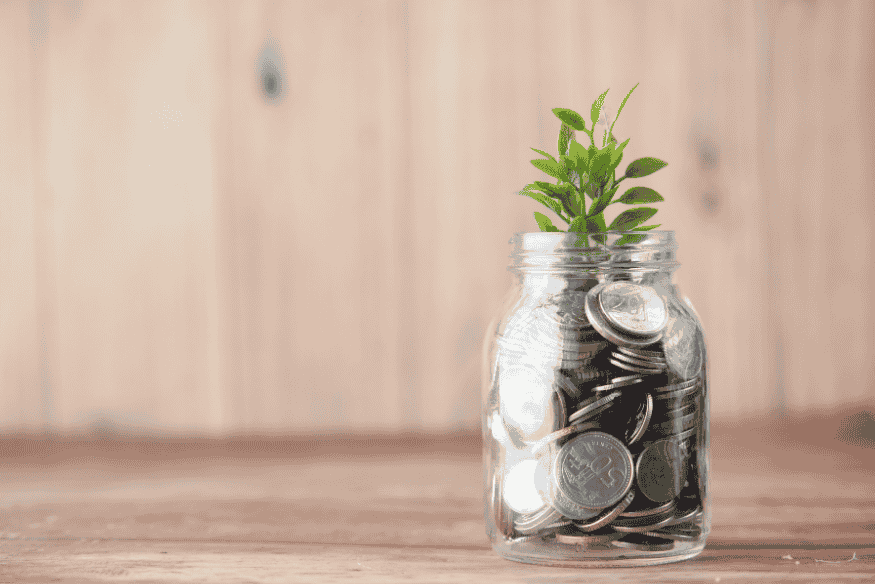 Jar filled with coins and a small plant symbolizing ethical financial growth