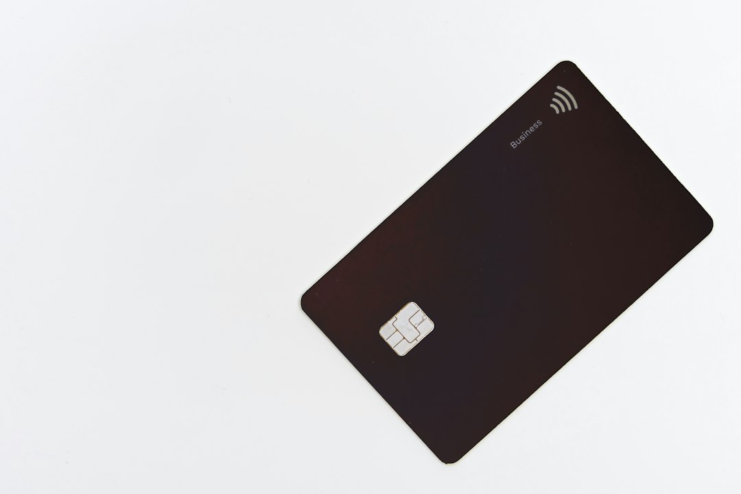 A black business credit card with a chip on a white background