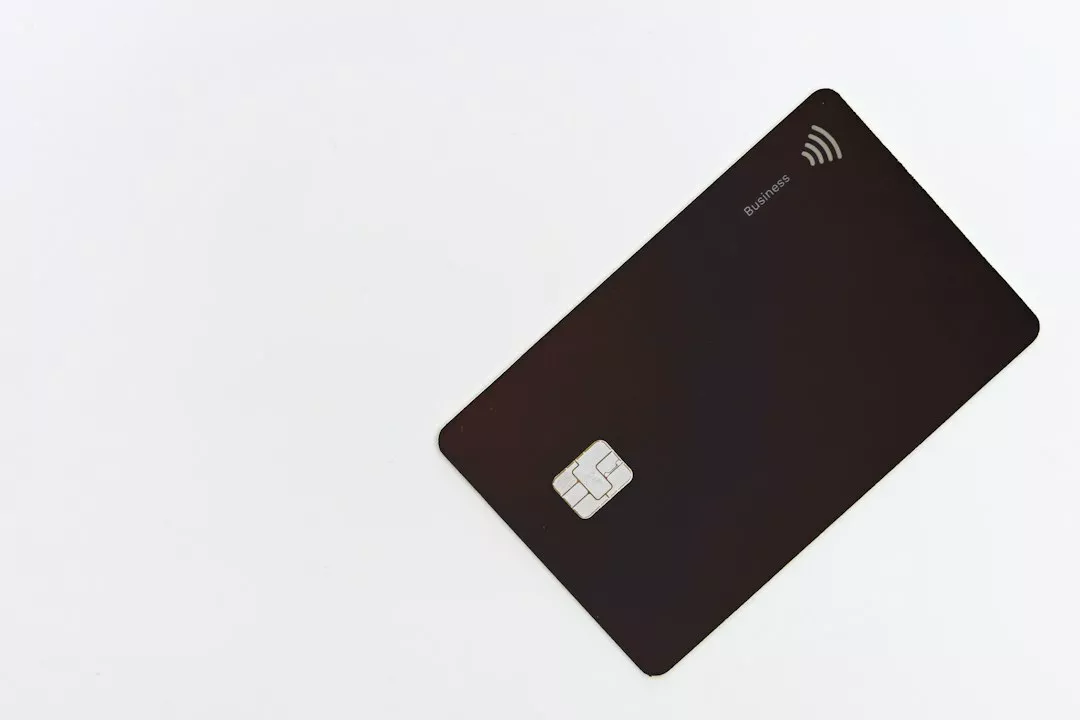A black business credit card with a chip on a white background