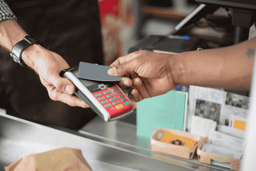 Person making a contactless payment using a credit card on a POS terminal
