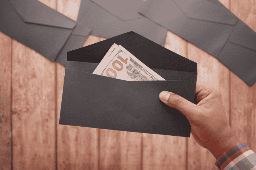 Hand holding a black envelope filled with US dollar bills, symbolizing cash remittance.